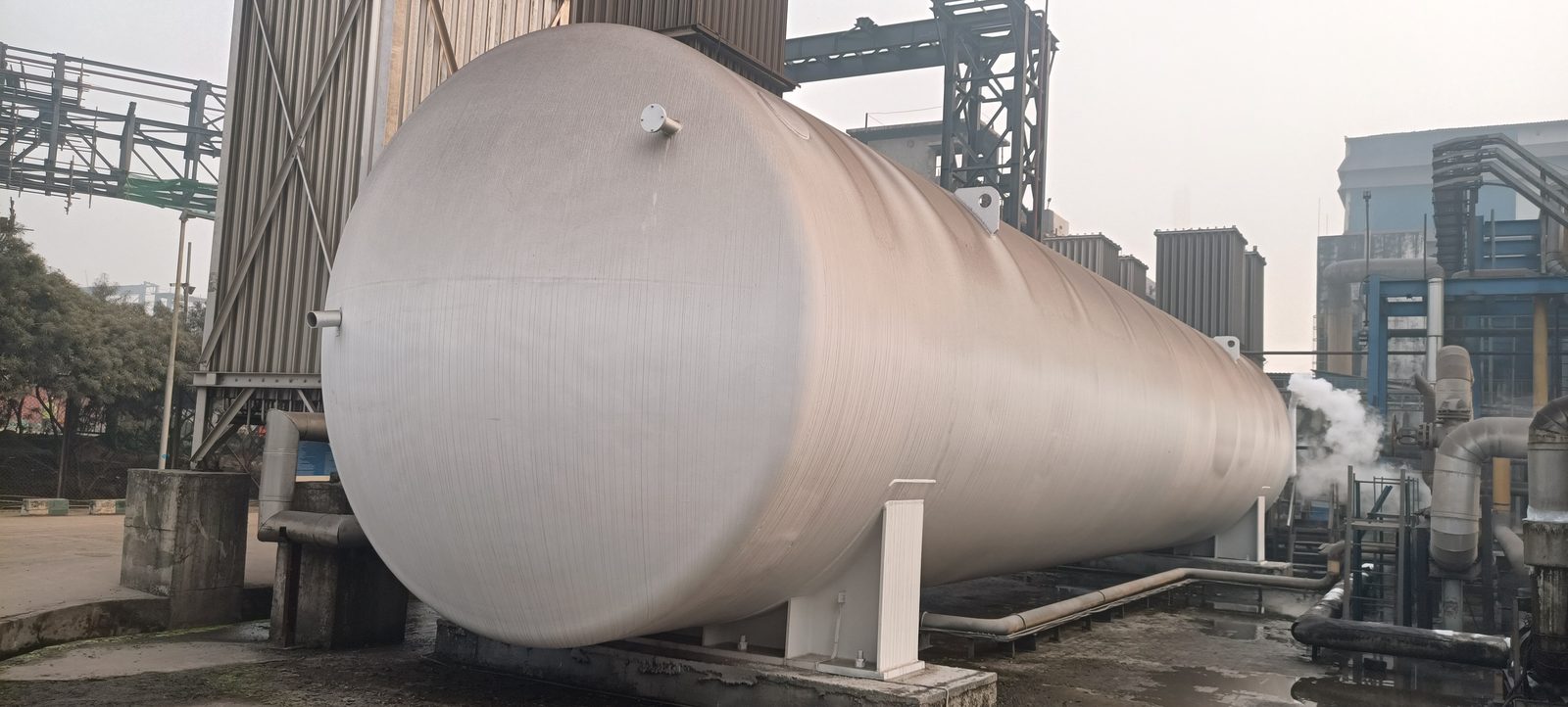 Blue-painted structural steel pipe rack framework carrying process and caustic soda lines